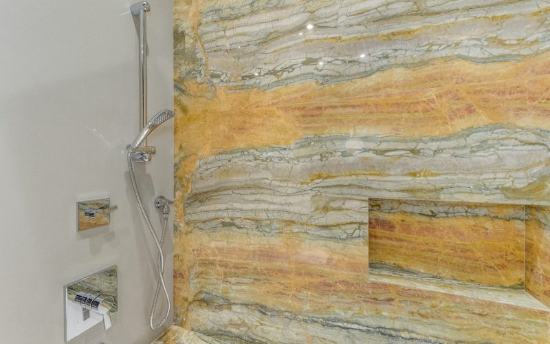 Yellow bathroom wall stone with hand shower in Glenview Princeton Club remodel