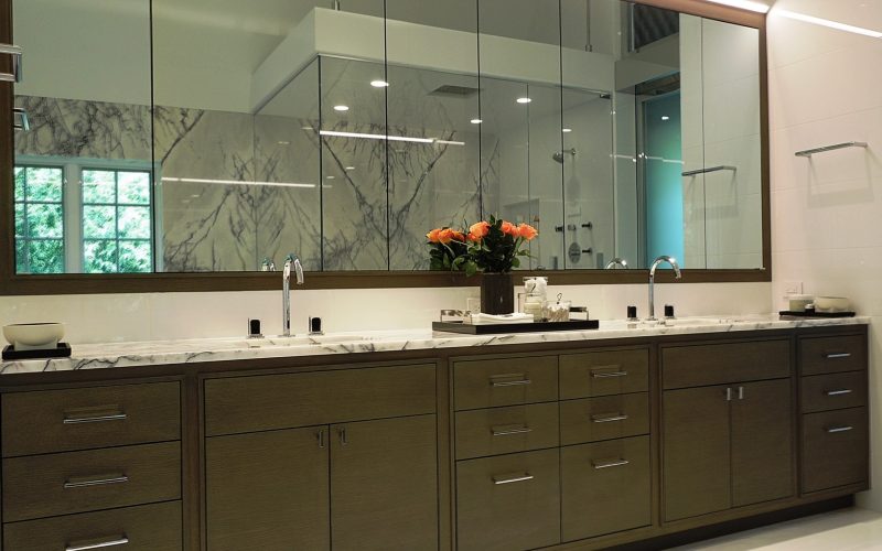 White bathroom countertop with mirror and brown vanity in Glenview Princeton Club remodel